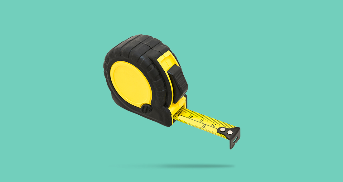 Retractable measuring tape in front of a teal background.