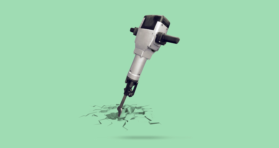 A jackhammer breaking ground in front of a pastel green background.